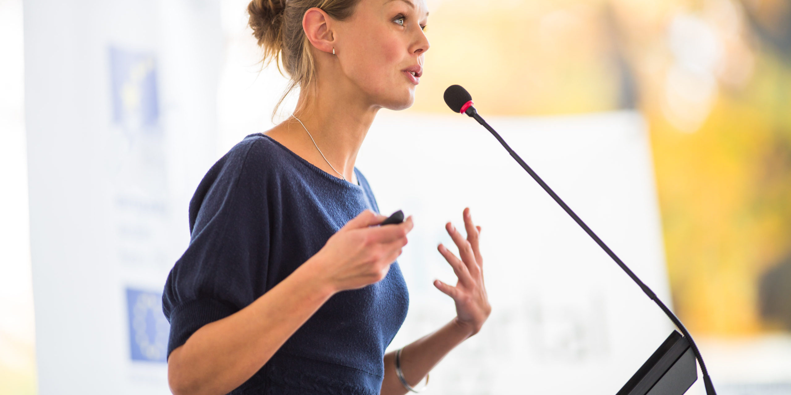 Pretty,,Young,Business,Woman,Giving,A,Presentation,In,A,Conference/meeting