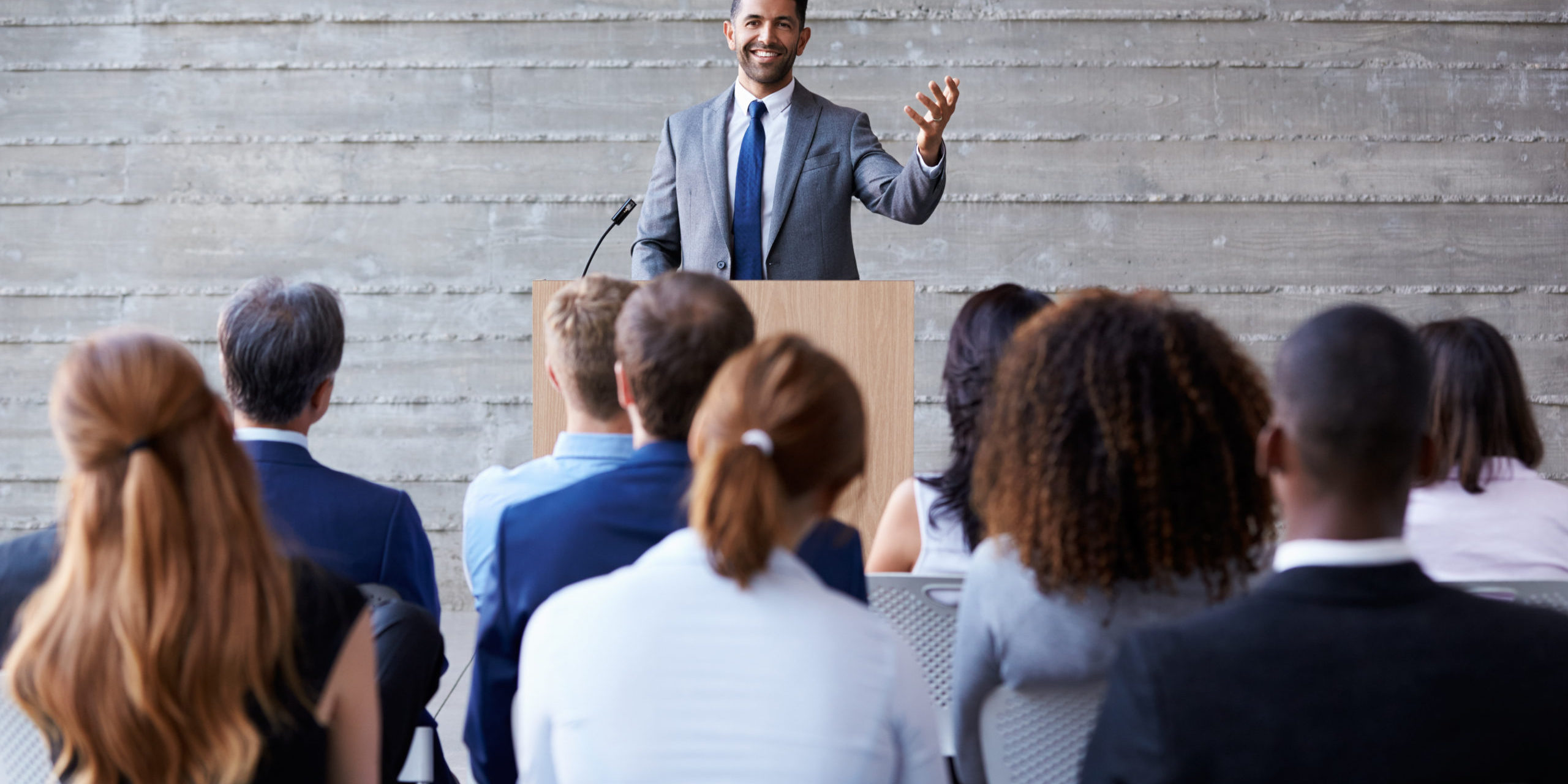 Businessman,Addressing,Delegates,At,Conference